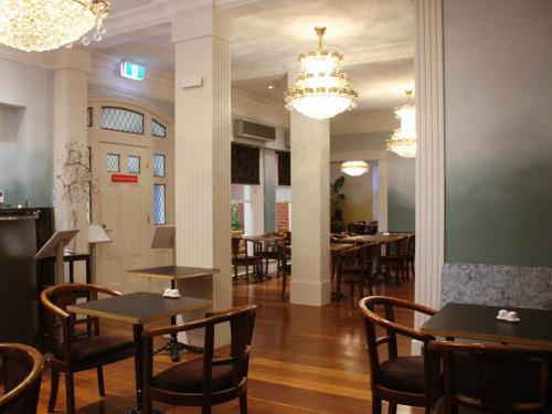 a dining room with tables and chairs and chandeliers at The Terrace Hotel in Perth