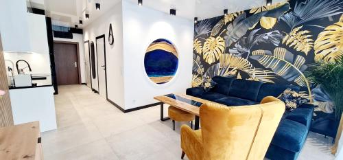 uma sala de estar com um sofá azul e uma mesa em Apartamenty Aquarius Gold Boszkowo em Boszkowo