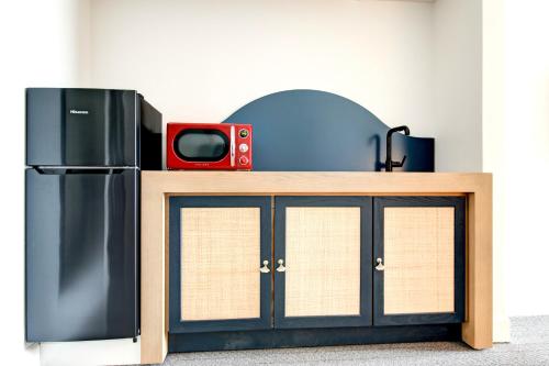 a table with a refrigerator and a tv on it at Elwood Hotel & Suites in Lexington