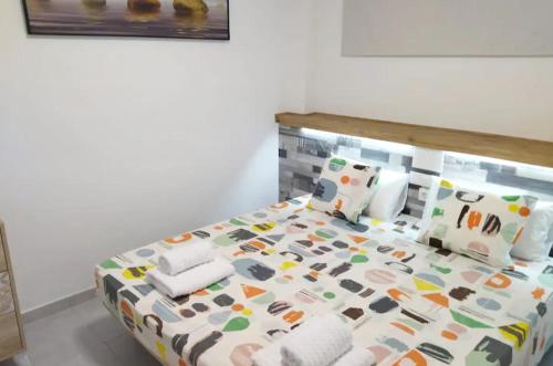 una camera da letto con letto e lenzuola e cuscini colorati di Playa del Inglés 5 min walk from Yumbo! 304 a Maspalomas