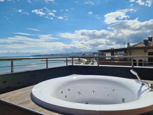 a bath tub on a balcony with a view of the ocean at Çepni's HOTEL in Samsun