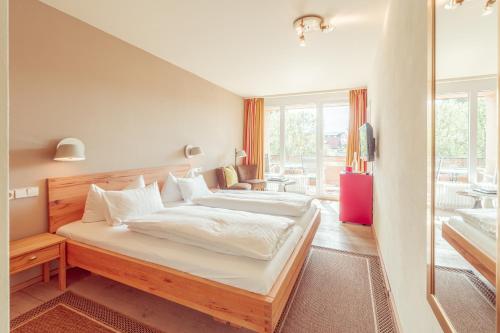 um quarto com uma cama grande e uma varanda em Hotel Restaurant zur Sonne St. Peter em Sankt Peter