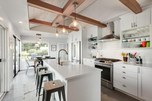 a kitchen with white cabinets and a kitchen island with stools at Saratoga Waterview Escape in Langley