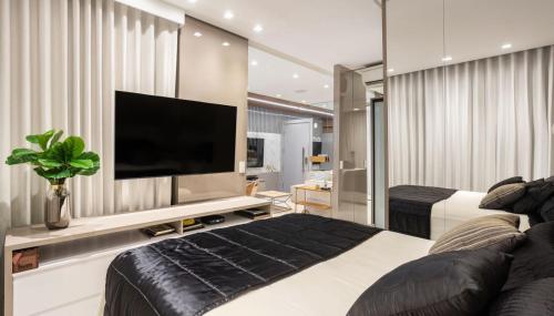 a bedroom with a bed and a flat screen tv at Refúgio Charmoso e Romântico no Vertigo Premium Studios in Campo Grande