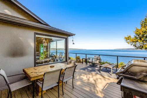 a deck with a table and chairs and a grill at Saratoga Waterview Escape in Langley