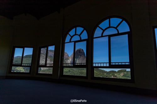 a room with windows with a view of a mountain at Vista Azul Hotel in Pedra Azul