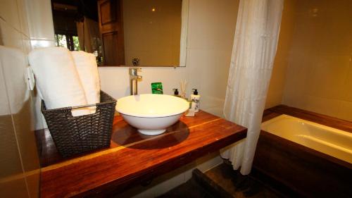 uma casa de banho com um lavatório e uma banheira em On Vacation Amazon em Letícia
