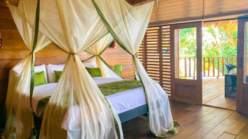 a bedroom with a bed with mosquito nets at On Vacation Amazon in Leticia