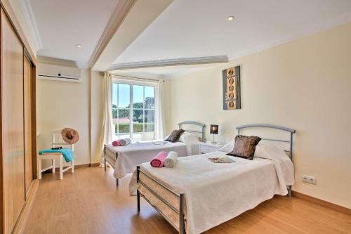 ヴァーレ・ド・ローボにあるVilla Beirais by Villa Plusのベッド2台と窓のある寝室