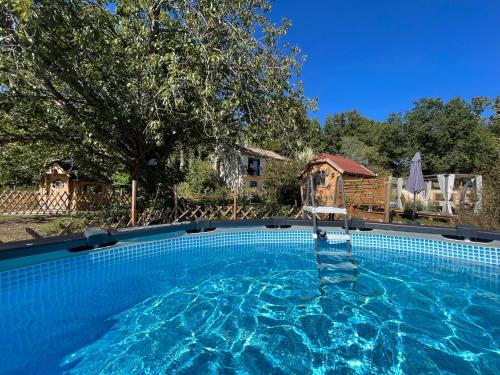 a large blue swimming pool with a house in the background at KOTAs Accueil Vélo - Chez Flo & Marc in Chouzy-sur-Cisse