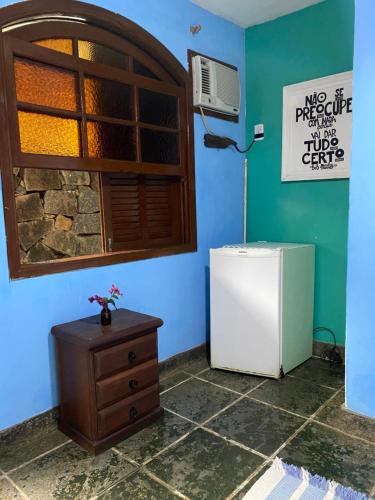 a blue room with a refrigerator and a cabinet at Pousada Canto Verde in Abraão