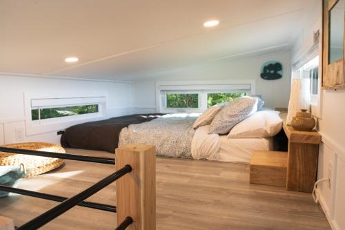 a bedroom with a bed and two windows at Tiny House Big View in Chilliwack