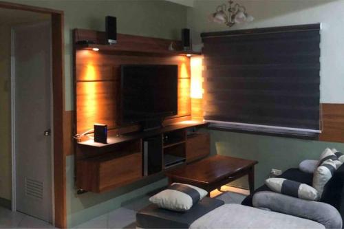 - un salon avec une télévision et un canapé dans l'établissement 3BR 70sqm Free internet, Penthouse unit in Ermita, Manila near US Embassy, à Manille