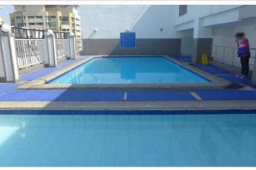 a large swimming pool with a person standing next to it at 3BR 70sqm Free internet, Penthouse unit in Ermita, Manila near US Embassy in Manila
