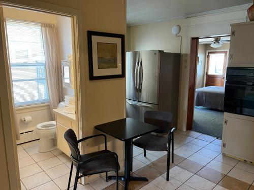 a kitchen with a table and chairs and a refrigerator at Simmons Motel and Suites in Hershey