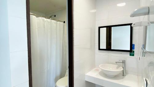 a white bathroom with a sink and a mirror at On Vacation Tower in San Andrés