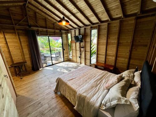 a bedroom with a large bed in a room with windows at Finca Hotel Pinares in La Pintada