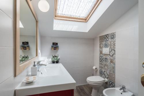 a bathroom with a sink and a toilet and a skylight at B&B L'Ulivo Fiumicino in Fiumicino