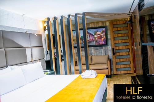 a hotel room with a bed and a chair at La Floresta de Cite Hotel in Cite