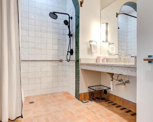 uma casa de banho com um chuveiro e um lavatório. em Elwood Hotel & Suites em Lexington