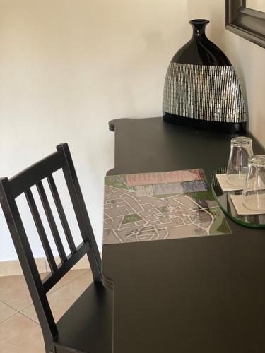 a black table with a chair and a vase at B&B STAZIONE DON CAMILLO in Brescello
