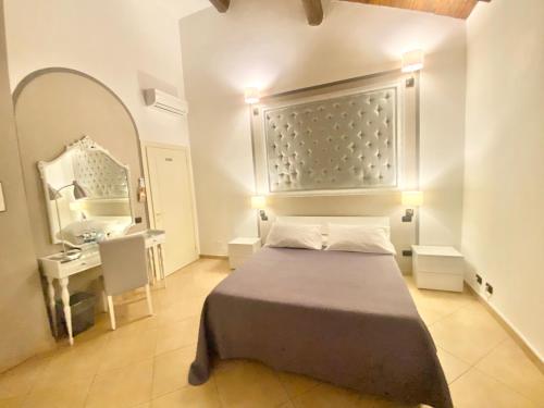 a bedroom with a bed and a vanity and a mirror at B&B STAZIONE DON CAMILLO in Brescello