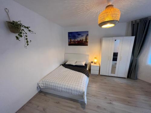 a bedroom with a bed and a pendant light at London Apartments - Free parking in Katowice