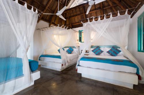 2 camas en una habitación con cortinas blancas en Aite Eco Resort, en Palomino