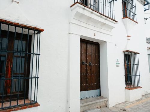 un edificio blanco con puerta y ventanas de madera en Mascotas 2, en Benaocaz