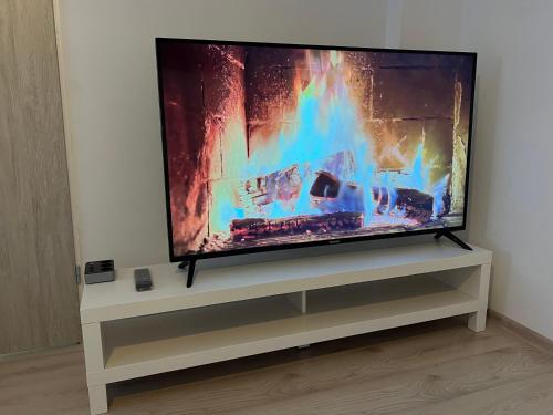 een flatscreen-tv zittend op een tv-standaard bij London Apartments in Katowice