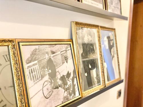 a group of framed photographs on a shelf at B&B STAZIONE DON CAMILLO in Brescello