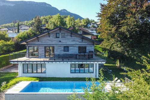 a house with a swimming pool in front of a house at La Petite Montagne in Saint-Jorioz