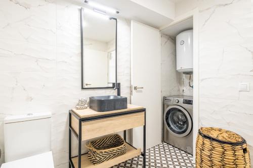 a laundry room with a sink and a washing machine at Torre Yago Deluxe 1-2 Levante Beach in Benidorm