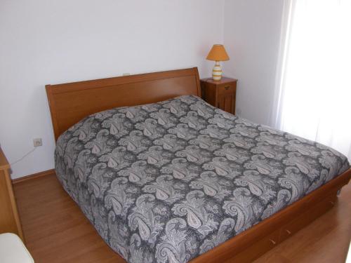 a bedroom with a bed with a gray comforter at Apartment Haramina in Baška