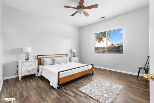 a white bedroom with a bed and a ceiling fan at NorthWest Farmhouse in Bakersfield