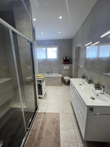 Un baño con ducha, lavabo y bañera. en SUPERBE HAUT DE VILLA AVEC VUE SUR LA MER, en Vence
