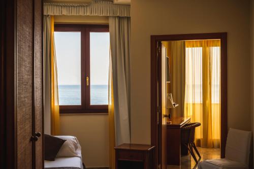 a room with a room with a window and a desk at Apulia Hotel Taranto Ara Solis in Lido Azzurro
