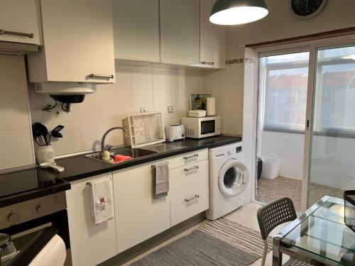 cocina con fregadero y lavadora en Confort Apartment 2 Bedrooms, en Alhos Vedros