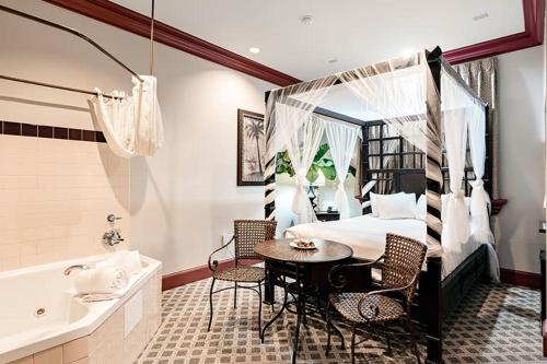 a bedroom with a bed and a table and a tub at Chateau Avalon in Kansas City