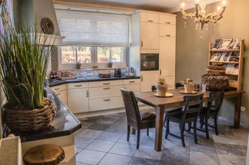 a kitchen with a table and chairs and a window at Landhuis Hotel de Hilkensberg in Broekhuizen