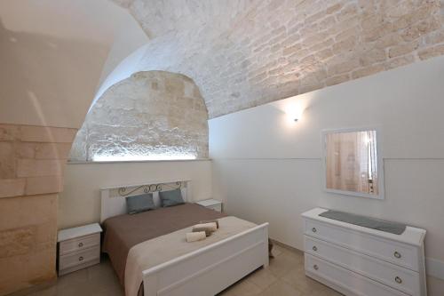 een slaapkamer met een bed en een bakstenen muur bij Casa vacanze nonna donata in Martina Franca