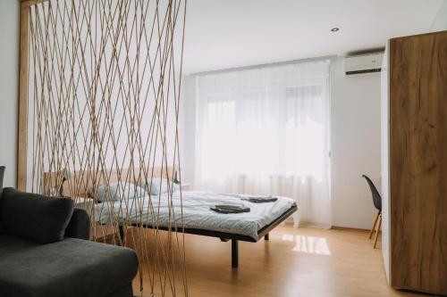 Pokój z łóżkiem, kanapą i oknem w obiekcie Constantin Inn w Niszu