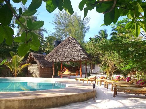 a resort with a swimming pool and a hut at Mpole Bungalows in Michamvi
