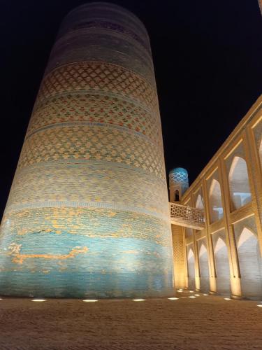 a large tower with lights on it at night at Khiva Ibrohim Guest House in Khiva
