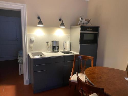 eine Küche mit einem Tisch und einer Theke mit einer Kaffeemaschine in der Unterkunft Garden View Apartment in Bad Segeberg
