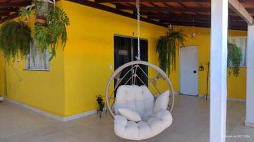 a swinging chair in a room with a yellow wall at Pousada Filhos da Canastra in Vargem Bonita