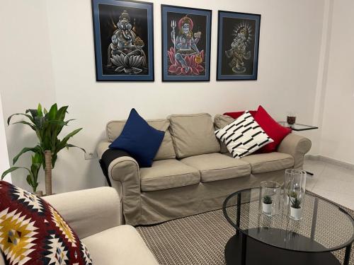 a living room with a couch and paintings on the wall at MC Apartments in Puerto del Rosario