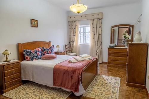 a bedroom with a bed and a dresser and a mirror at Quinta da Laceira - Douro Valley - Alojamento Local in Vila Real