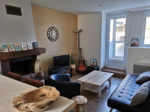een woonkamer met een bank en een tafel bij Les Embruns Méloriens in Saint-Méloir-des-Ondes