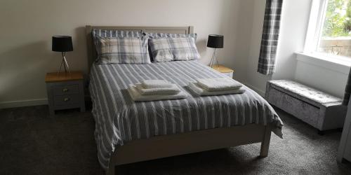 a bedroom with a bed with three pillows on it at Jaymar in Fife